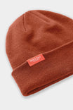 Dovetail Beanie in Paprika displayed from above, showing the soft acrylic knit texture and woven Dovetail logo on the cuffed women's beanie