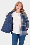Dovetail Workwear Durham Reversible Quilted Shirt Jac in Loden Green Plaid shown open to reveal quilted lining, worn by a woman over a cream henley and blue jeans