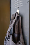 Grey Freshley HOTSWAP™ Drop Seat Thermal Denim Overalls by Dovetail Workwear hanging on a hook, displaying the thermal lining and reinforced construction