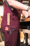 Dovetail Workwear x NoSo DIY Repair Patches displayed on maroon work pants pocket, showing various fabric patches including ruler and scissors for scale