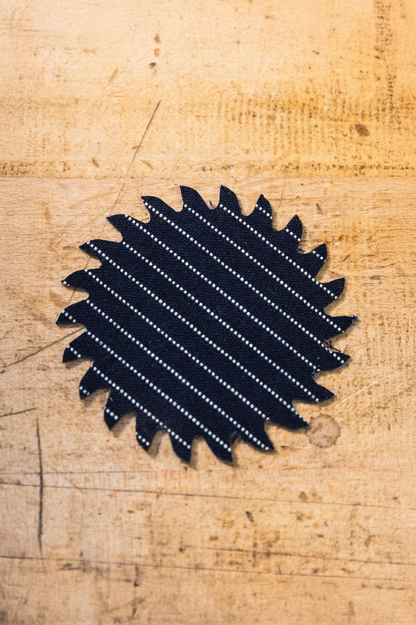Black Denim Pocket Patch from Dovetail Workwear x NoSo DIY Repair Patches, featuring a pocket patch design, displayed on natural wood surface
