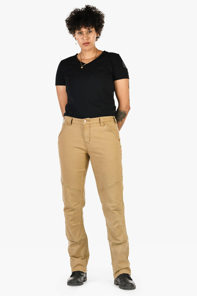 Woman wearing Dovetail Workwear GO TO™ Stretch Canvas Pant in Sawdust Brown with black v-neck tee, showcasing articulated knee panels and tool loop details