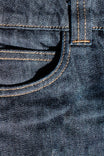 Close-up detail of the Dovetail Workwear DX Bootcut Pant in FR Denim, showing the signature stitching and iconic bootcut silhouette in indigo denim