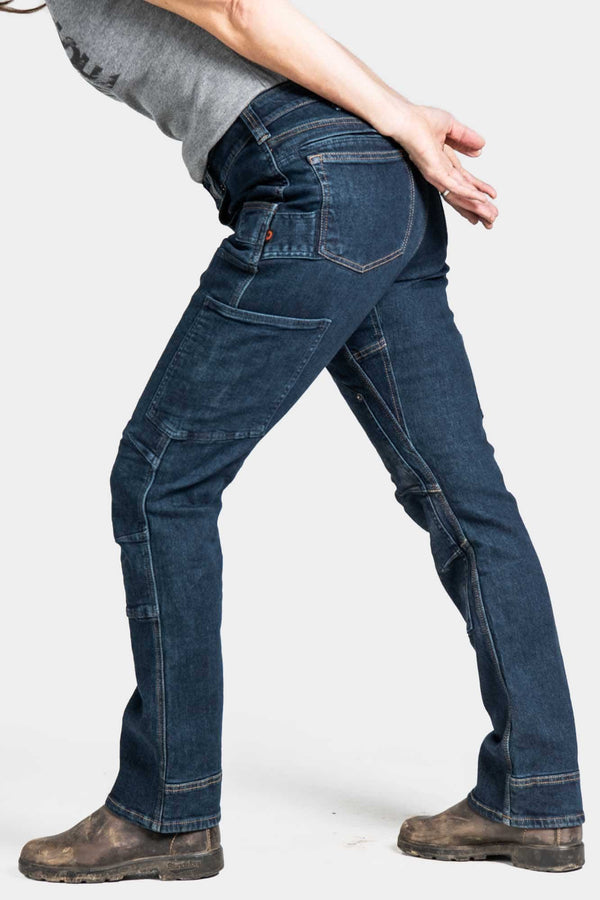 Back view of a woman wearing Dovetail Workwear's Britt X Pant Power Hemp in Indigo, showcasing the reinforced knees and straight leg fit with nested pockets