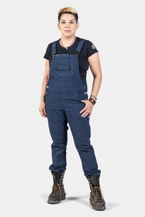 Freshley Overalls in Wabash Stripe by Dovetail Workwear displayed on a woman wearing a black tee, featuring striped denim with flex suspenders and reinforced knees