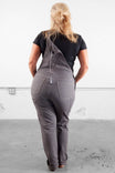 Back view of a woman wearing Dovetail Workwear Freshley Overalls in Grey Canvas, showcasing the reinforced knees and nested pockets