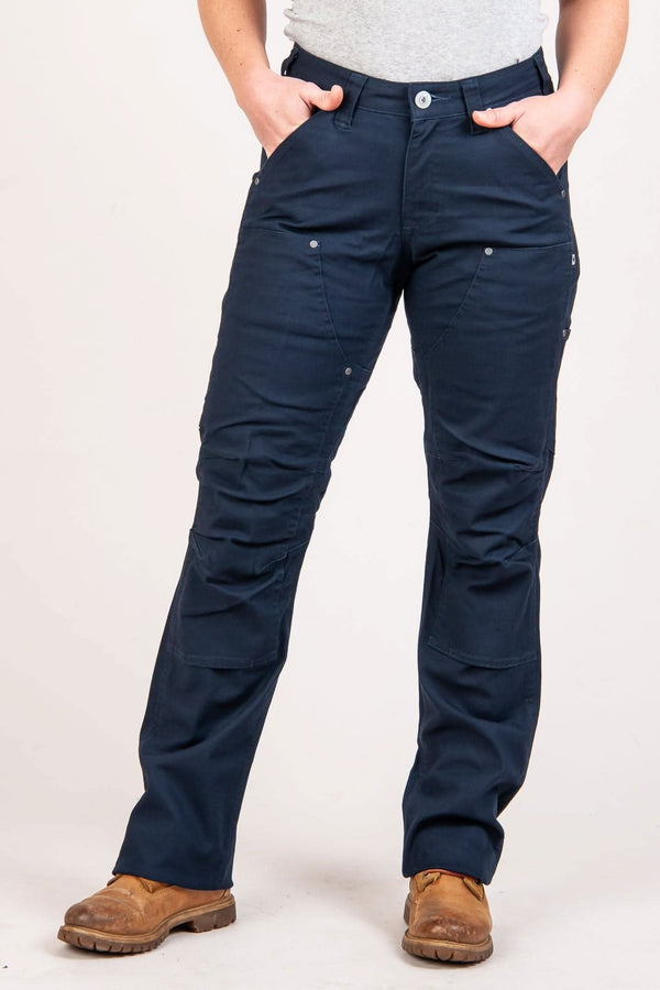 Front view of a woman wearing the Dovetail Workwear Anna Taskpant in Uniform Navy Canvas, featuring reinforced knees, Hip Slot™ Tool loop, and nested pockets