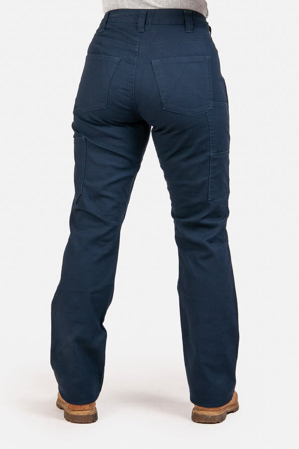Back view of a woman wearing Dovetail Workwear's Anna Taskpant in Uniform Navy Canvas, showcasing nested pockets, reinforced knees, and a straight leg silhouette