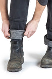 Detail view of a woman pulling up the Britt Utility Pant in Black Stretch Thermal Denim by Dovetail Workwear, showing the reinforced knee area and crotch gusset