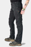 Side view of a woman wearing Dovetail Workwear's Britt Utility Pant in Black Stretch Thermal Denim, featuring visible Hip Slot™ Zip pocket, reinforced knees, and straight leg fit with hiking boots