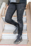 Woman climbing stairs wearing Dovetail Workwear Christa DIY Pant in Black Performance Modal with reinforced knees and lace-up boots