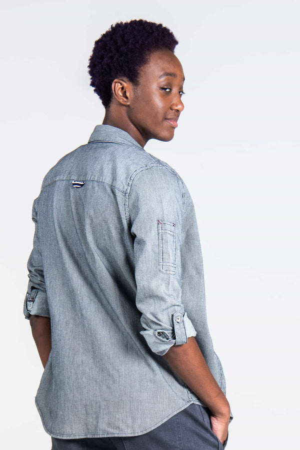 Back view of a woman wearing the Givens Work Shirt in Indigo Stripe by Dovetail Workwear, showcasing the sleeve pocket and lightweight striped fabric design