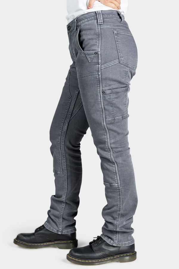Side view of a woman wearing the Maven X Slim Pant in Grey Stretch Thermal Denim by Dovetail Workwear, featuring nested pockets and reinforced knees