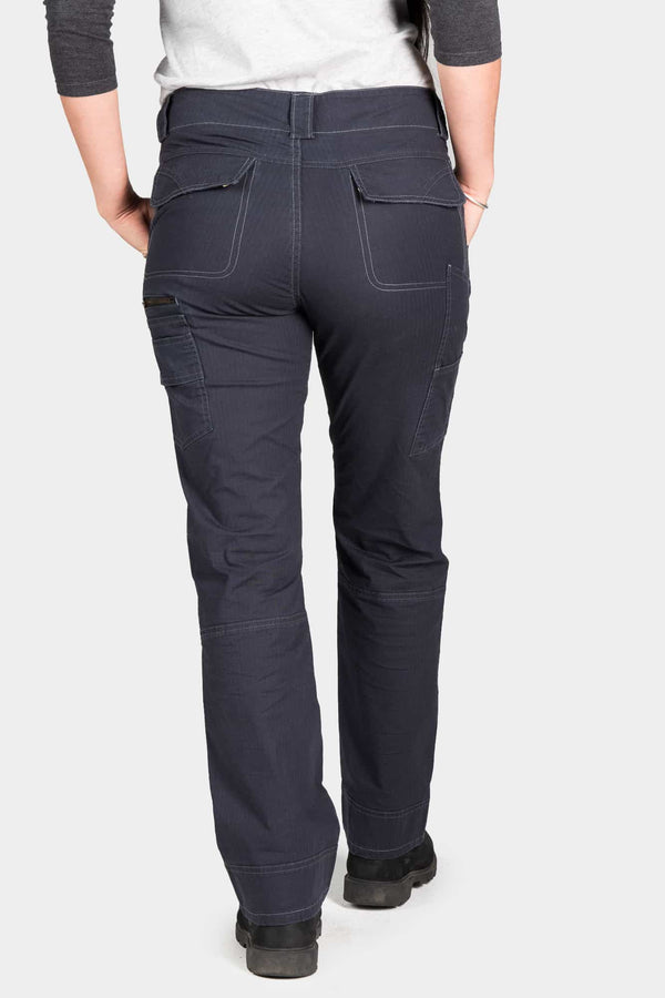 Back view of a woman wearing Dovetail Workwear's Day Construct Pant in Lightweight Dark Navy Ripstop, showcasing the relaxed fit, nested pockets, and reinforced knee area with kneepad slot details
