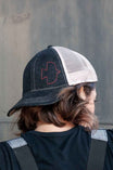 Back view of a woman wearing the Dovetail Embroidered Shop Cap in blue/black denim with white mesh panels and embroidered logo detail