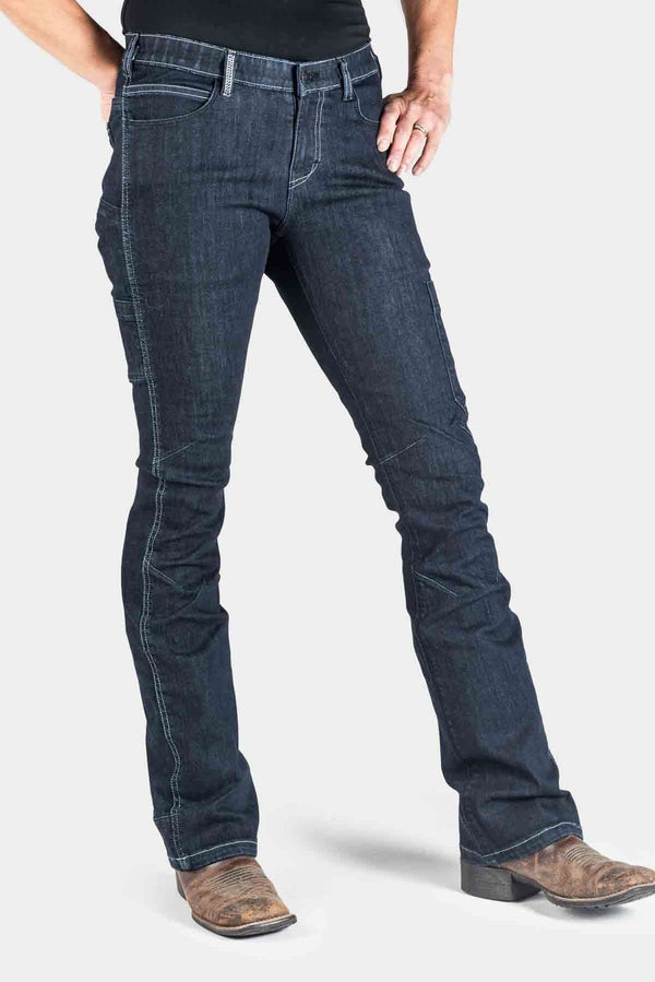 DX Bootcut Pant in CORDURA® Indigo Denim by Dovetail Workwear, front view on a woman wearing brown cowboy boots, showcasing the bootcut silhouette and visible EZWaist™ tool loop detail