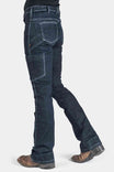 Side view of a woman wearing Dovetail Workwear's DX Bootcut Pant in CORDURA® Indigo Denim, showcasing the bootcut silhouette, phone pocket, and articulated knee design with brown boots