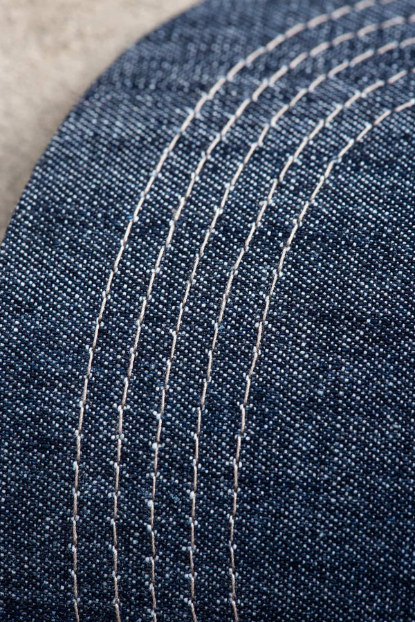 Close-up detail of the Dovetail Embroidered Shop Cap showing blue denim fabric with contrast cream-colored mesh in parallel lines