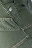 Detail shot of Dovetail Workwear Maven X Pant in Moss Green Canvas showing reinforced knee area, tool loop, and metal button hardware on pocket