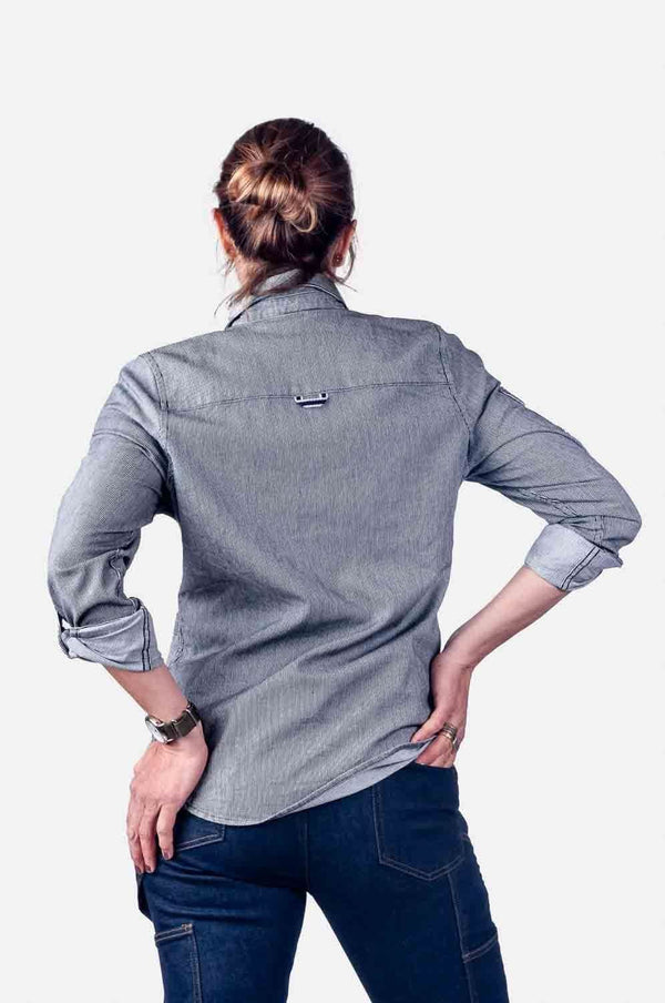 Back view of a woman wearing the Givens Work Shirt in Indigo Stripe by Dovetail Workwear, showing the locker loop and relaxed fit paired with dark jeans