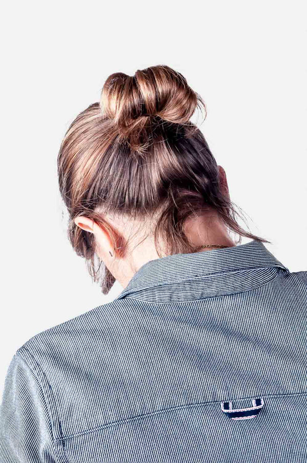 Back view of a woman wearing the Givens Work Shirt in Indigo Stripe by Dovetail Workwear, showcasing the chest pocket and striped fabric detail