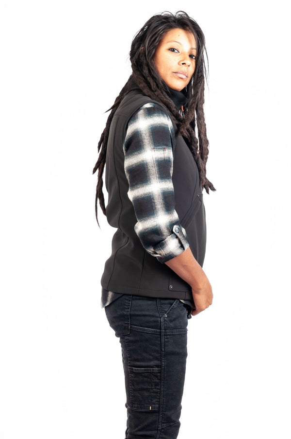 Back view of a woman wearing the M'fon Work Vest by Dovetail Workwear in black over dark jeans
