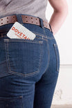 Dovetail Workwear Gift Certificate displayed in the back pocket of dark blue jeans worn by a woman, featuring the brand logo in red text on white card